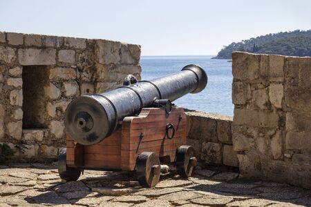 Ancient iron cannon on wooden mount on Dubrovnik stone rampartの写真素材