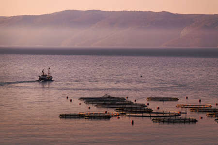 Fishing boat near fish farm in early morning on island Brac in Croatiaの写真素材