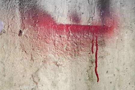 Weathered damaged wall with red paintの写真素材