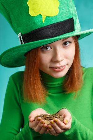 Red hair girl in Saint Patrick s day hat isolated on green grunge backgroundの写真素材