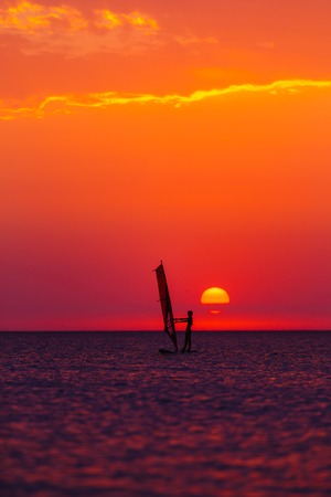 windsurfer silhouette against a sunset background at the seaの写真素材