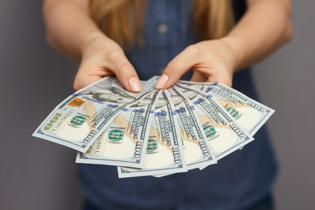 Fan of 100 dollar banknotes in beautiful woman handsの写真素材