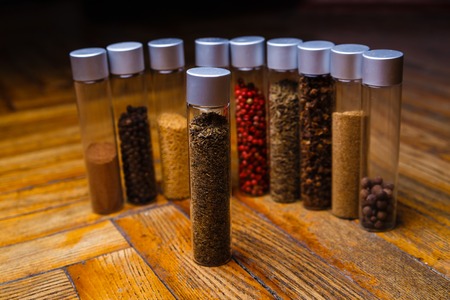 Assorted ground spices in bottles on wooden backgroundの写真素材