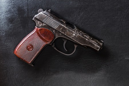 Weathered generic russian soviet semi-automatic 9mm pistol on black leather backgroundの写真素材