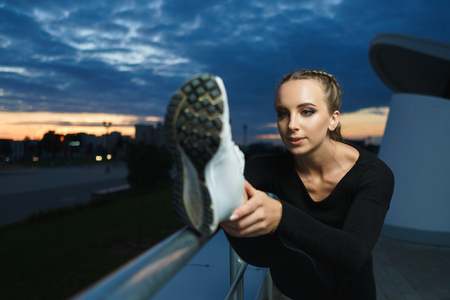 Concept: healthy lifestyle, sport. Attractive happy girl fitness trainer stretch outdoor workout at...