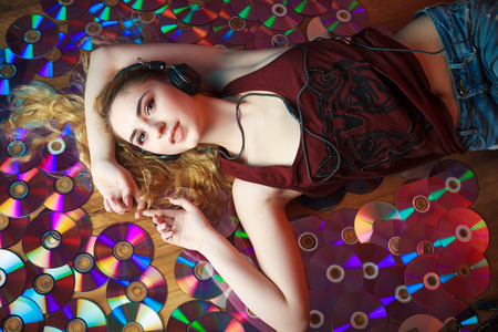 Concept: hipster lifestyle, relaxation. Beautiful young woman in headphones have fun and listen...