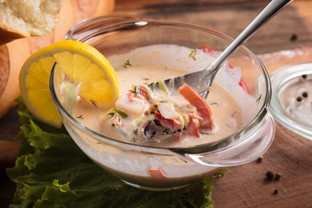 Concept: restaurant menus, healthy eating, homemade, gourmands, gluttony. Creamy soup with seafood on a messy weathered wooden background with ingredients.の写真素材