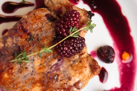 Concept: restaurant menus, healthy eating, homemade, gourmands, gluttony. Pork steak on the bone with cherry-ginger sauce with ingredients on messy sackcloth background. Top-down view.の写真素材