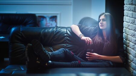 Concept: recreation, millennial, nightlife. Beautiful young woman relax in empty underground night club.の写真素材