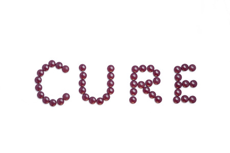 Cure written with brown pills - white backgroundの写真素材