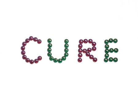 Cure written with brown pills - white backgroundの写真素材