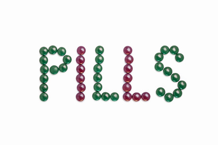Pills written with green and purple pills  - white backgroundの写真素材