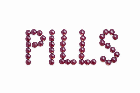 Pills written with purple pills  - white backgroundの写真素材