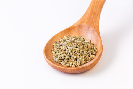 Fennel seeds in a wooden spoon view from topの写真素材