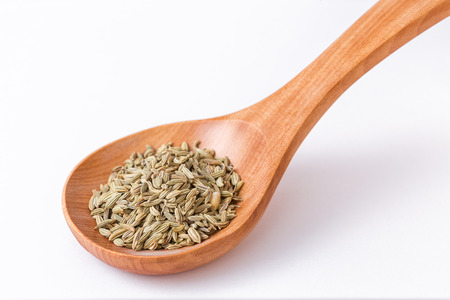 Fennel seeds in a wooden spoon. Spoon diagonally closeup on fennelの写真素材