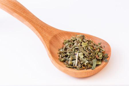 Infusion leaves in wooden spoon spoon diagonally. Closeup on leavesの写真素材