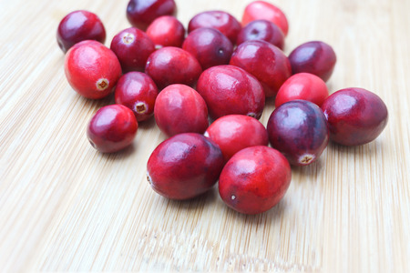 Fresh Cranberries on wood background (light wood color)の写真素材