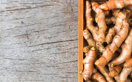 Fresh turmeric roots on wood background, herb and healthy care conceptの写真素材