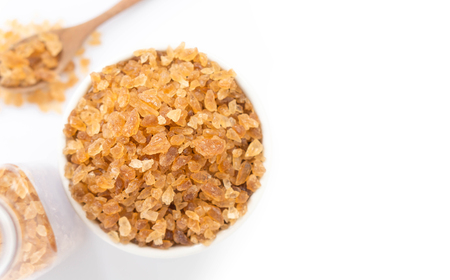 Closeup brown sugar on ceramic bowl isolated with white background, top viewの写真素材