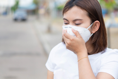 Closeup woman wearing face mask for protect air polution, health care and medical conceptの写真素材