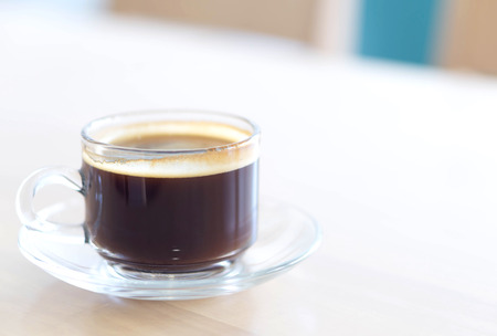 Closeup glass of hot americano coffee on wood table, selective focus, vintage toneの写真素材