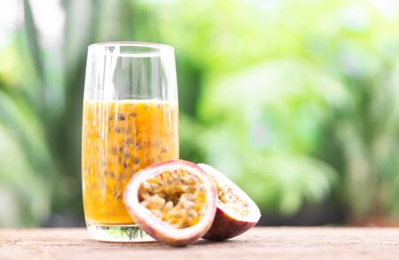 Glass of passion fruit juice wood table with green nature background, food healthy concept, selective focusの写真素材