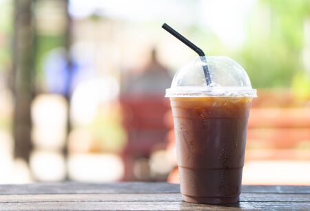 Close up glass of ice americano coffee on wood table, selective focusの写真素材