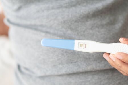 Closeup woman hand holding pregnancy test with happy moment, health care concept, selective focusの写真素材