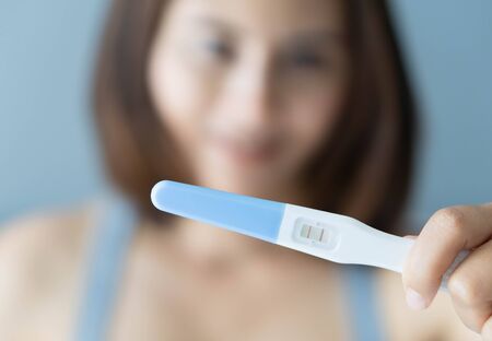Closeup woman hand holding pregnancy test with happy moment, health care concept, selective focus