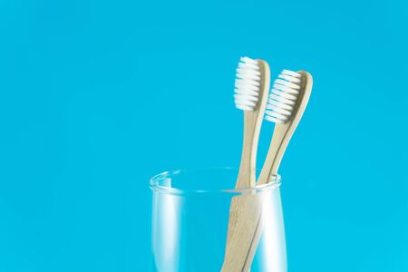 Close up wooden toothbrush in glass with blue background, selective focusの写真素材
