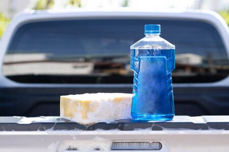 Close up bottle of car wash soap with yellow sponge for washing, selective focusの写真素材
