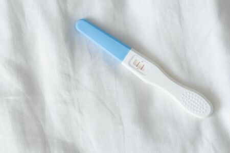 Pregnancy test on white bed background, health care and medical conceptの写真素材