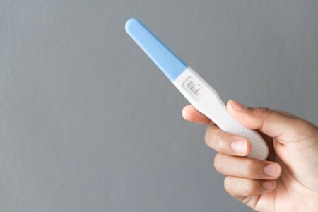 Closeup woman hand holding pregnancy test with happy moment, health care concept, selective focusの写真素材