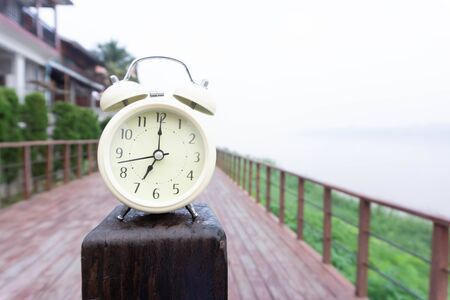 Alarm clock with nature and fog background in the morningの写真素材