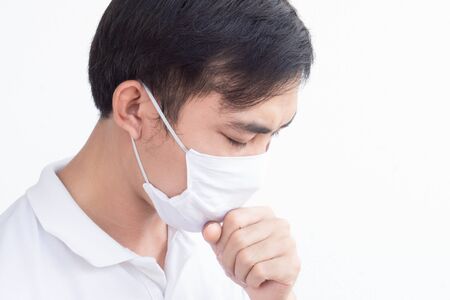 Closeup man wearing face mask for protect air polution or virus covid 19 with cough on white background, health care and medical conceptの写真素材