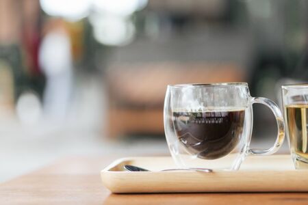 Closeup glass of hot americano coffee on wood table, selective focus, vintage toneの写真素材