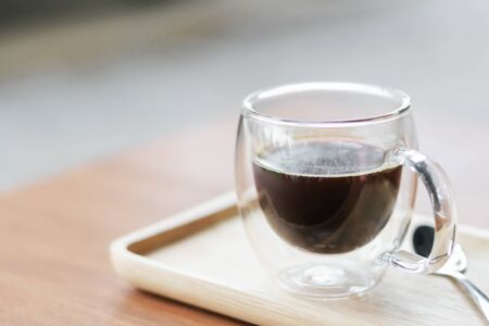 Closeup glass of hot americano coffee on wood table, selective focus, vintage toneの写真素材