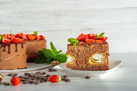 Mousse cake with profiteroles inside and strawberriesの写真素材