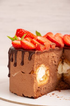 Mousse cake with profiteroles inside and strawberries