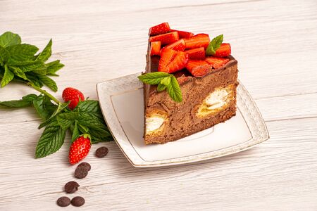 Mousse cake with profiteroles inside and strawberriesの写真素材