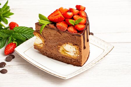 Mousse cake with profiteroles inside and strawberriesの写真素材