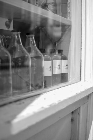 Glass bottles lined up for display in a vendor windowの写真素材