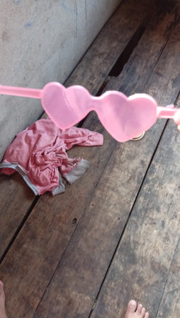 Pink heart shaped glasses on a wooden floor, valentine's dayの写真素材