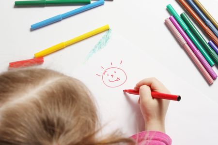 The girl draws bright and cheerful drawingの写真素材