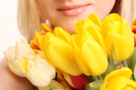 The beautiful woman with bouquet of yellow tulipsの写真素材