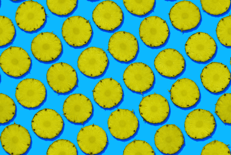 Pineapple slices on blue background, seamless patternの写真素材