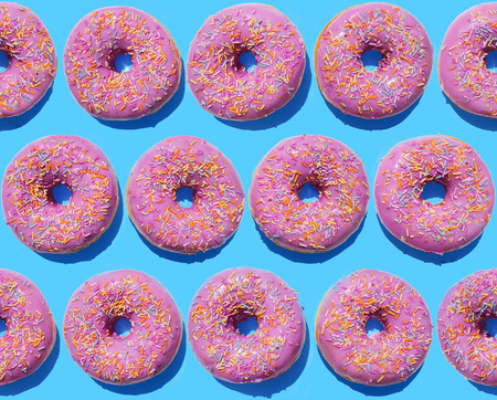 Pink ring doughnuts on blue background, seamless pattern