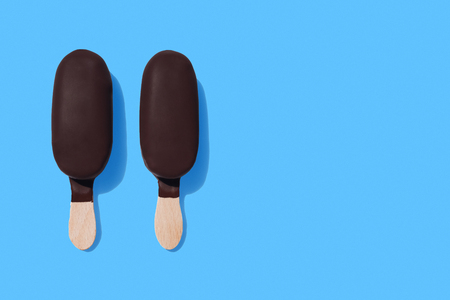 Dark chocolate ice-cream bars on bright blue backgroundの写真素材