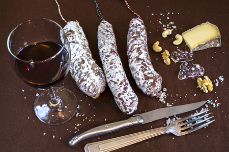Aperitif with red wine, salami, cheese and nutsの写真素材