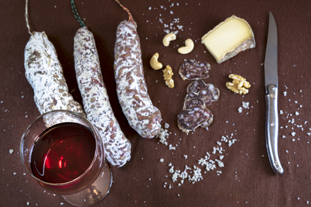Aperitif with red wine, salami, cheese and nutsの写真素材